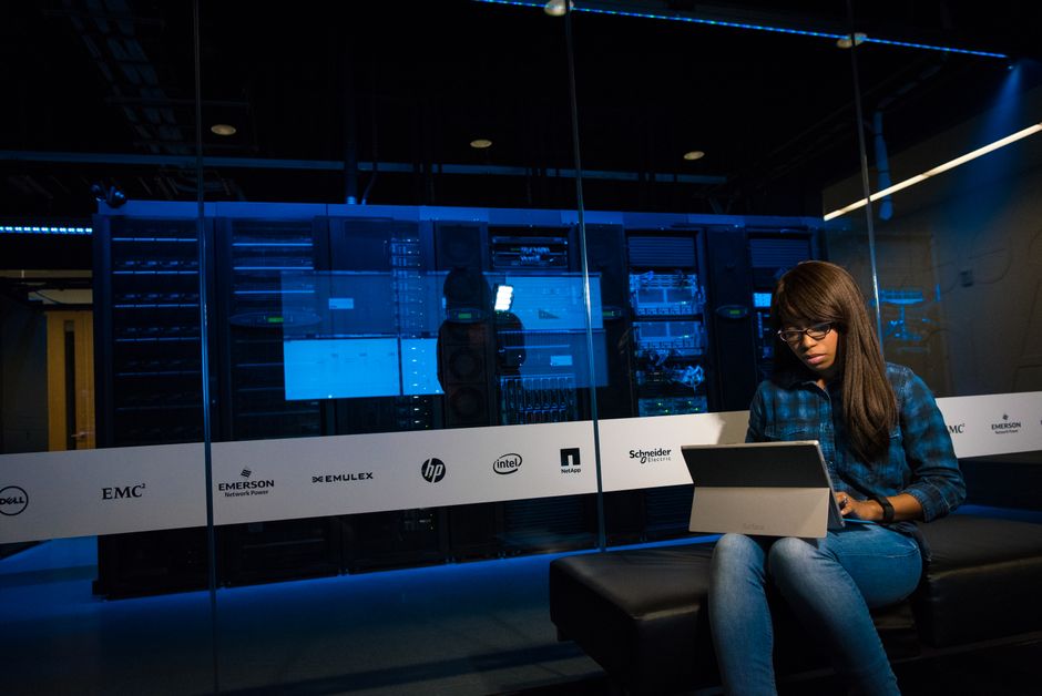 Person working on a laptop in a server room